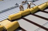 Silvercote's Energy Saver FP system is a high R-value insulation and leading-edge fall protection system consisting of a network of straps (white-painted, zinc-coated banding), a bright white support fabric and unfaced fiberglass blanket insulation.