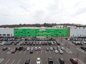 The vibrant green entryway consists of an arrangement of three horizontally oriented insulated metal panels (IMPs) in shades of green