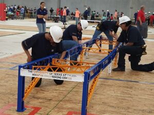 Student engineers constructing project for steel bridge competition