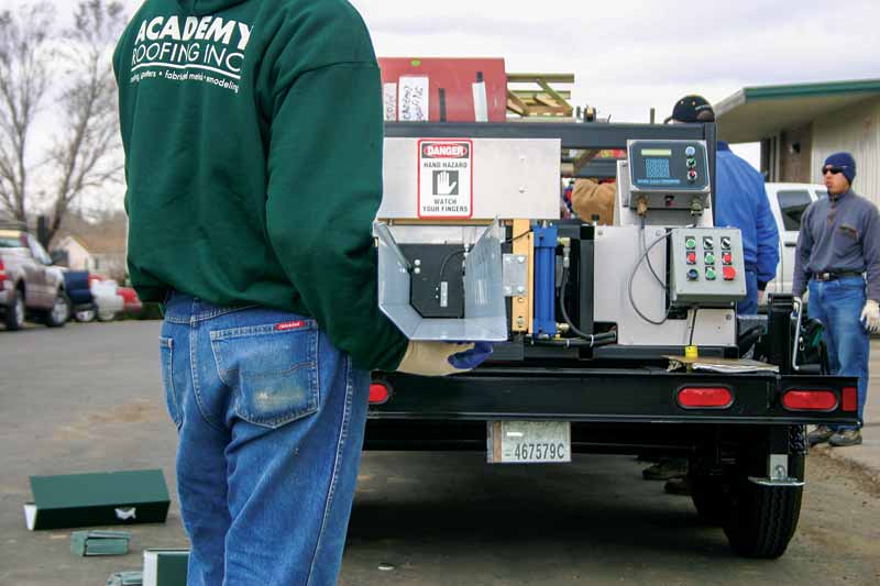 Courtesy New Tech Machinery A worker pulls a gutter machine off a truck.