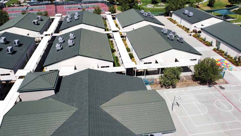 Courtesy Westlake Royal Building Products A series of buildings with stone-coated roofing beside a basketball court.