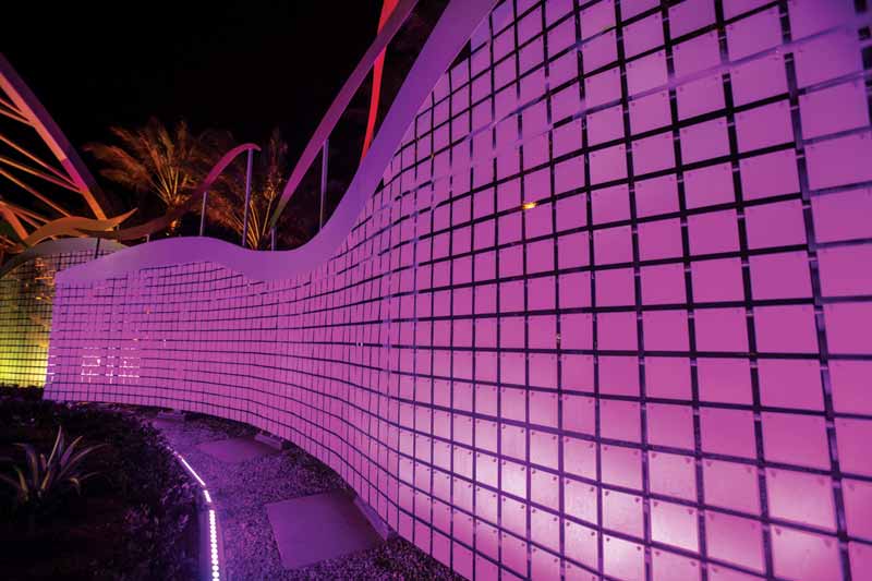 A metal building featuring a facade accentuated with pink-colored panels. 