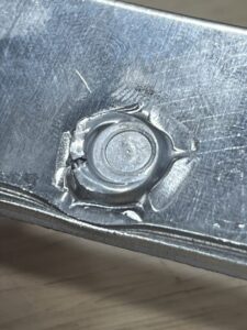 A close up of a cracked aluminum panel. 