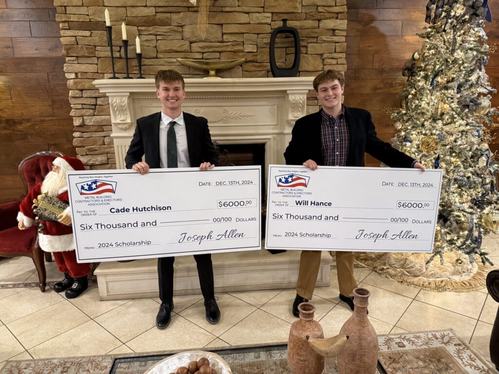 two people holding large checks