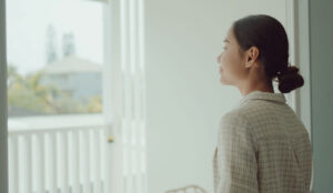 An Asian tenant stares comfortably out her window.