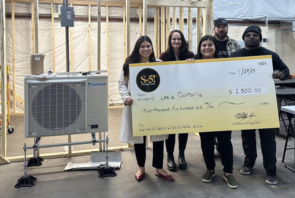 Three women and two men hold a prop check worth $2,500.