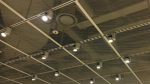 Framed ceiling panels using expanded metals painted to match the substructure optically hide conduit, plumbing, and ductwork.