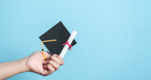 Hand holding the education cap paper cut, leading to the success goal. Taking strategic steps towards graduation. Career path and first for business, Graduation achievement goals concept. Graduation cap for possible metal construction professional.