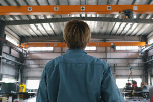 Asian Mature Male Industrial Worker Looking At Camera At Factory, representing job losses in the construction industry. 