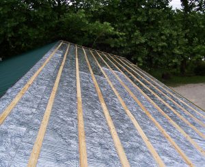 Photo courtesy rFOIL Insulation Products The installation of reflective insulation on a roof .