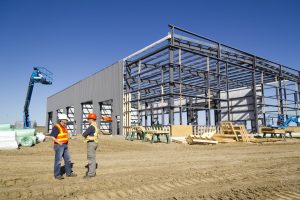 A metal construction jobsite with contractors speaking. 